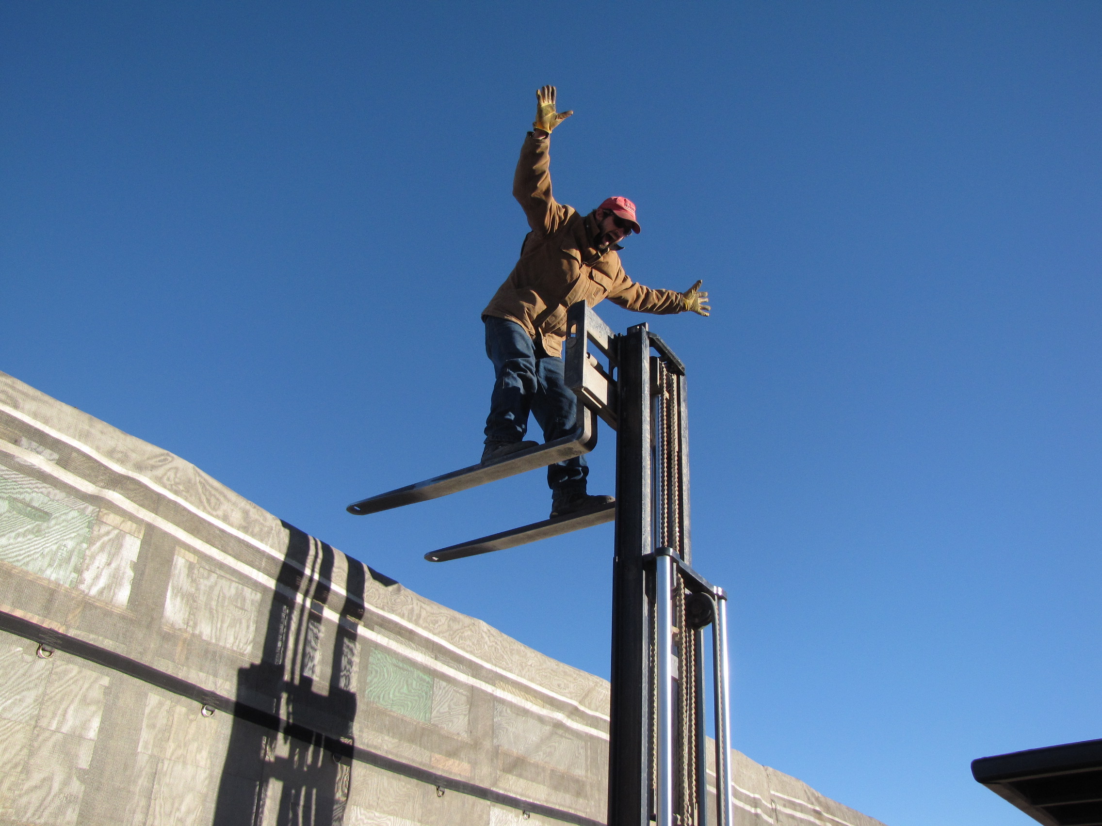 Image result for man standing on forklift blades